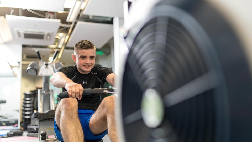 Student using the rowing machine at the gym