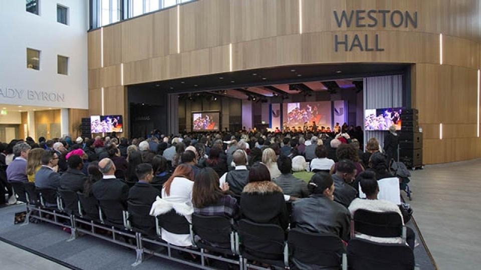 Weston Hall auditorium with people sitting and watching a display