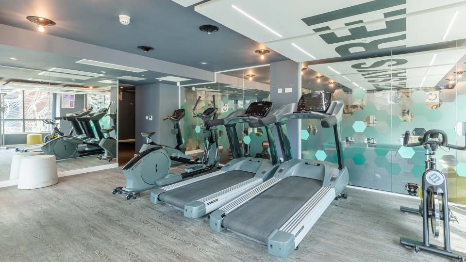 Modern-looking gym with glass walls, treadmill and cycling machine