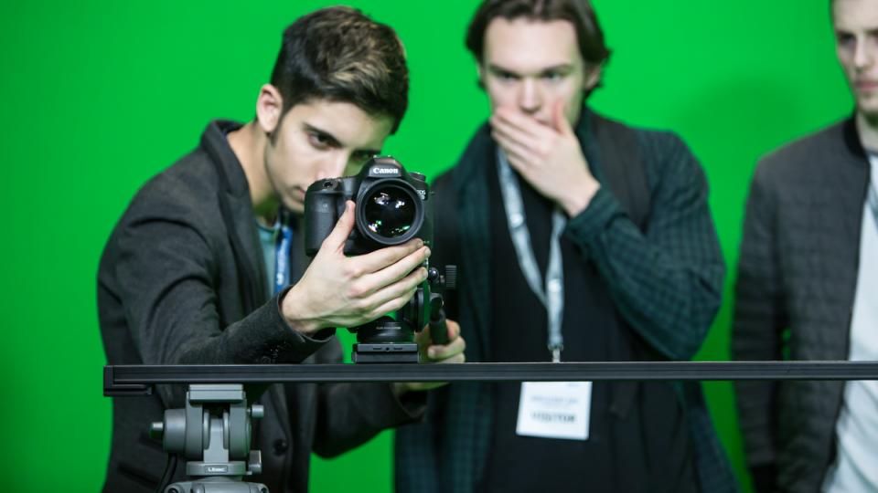 A student operating a camera in a film studio