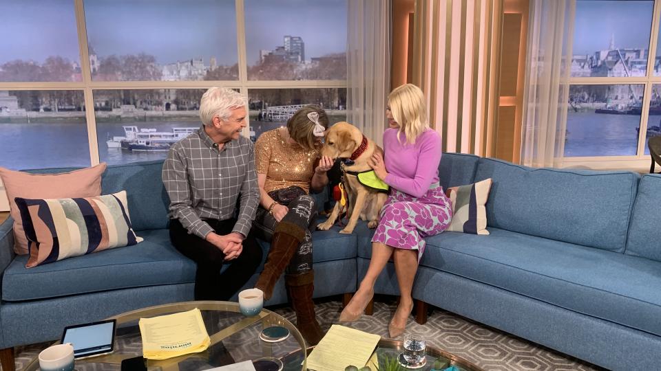 UWL alumna Chloe Hammond sitting and paying attention to Ocho the dog on the This Morning couch with Holly Willoughby, Phillip Schofield.