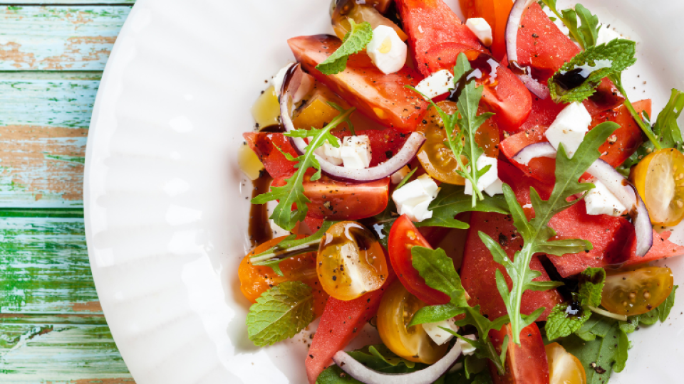 A feta cheese and tomato salad, served on a white plate.