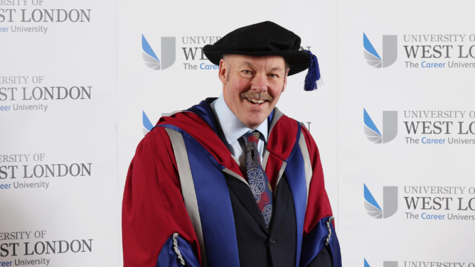 Carl Lomas is wearing a gown as an honorary graduate.