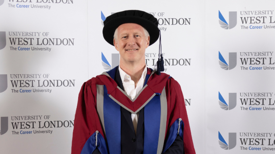Russ Lidstone is wearing a gown as an honorary graduate