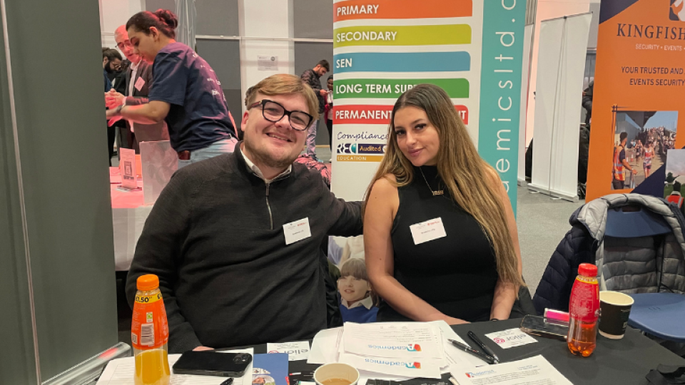 Two reps sitting in a booth at the University of West London Spring part-time jobs fair