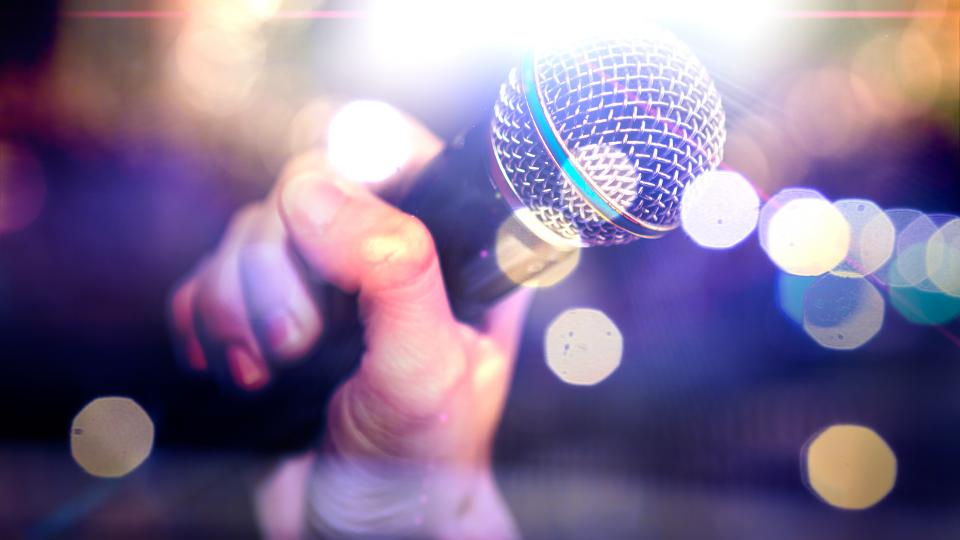 close up of a microphone being held by a singer