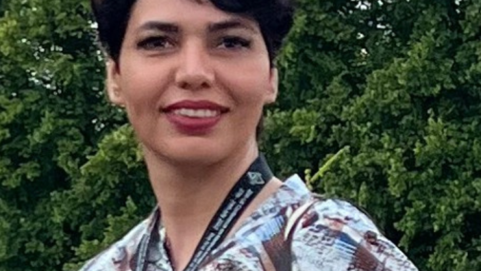 Neda Azarmehr is smiling in front of some green trees