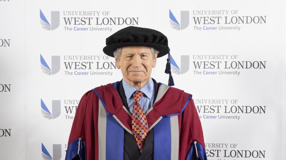 Michel Escoffier wearing red and purple honorary robes at the UWL November 2023 graduation ceremony
