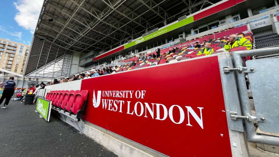 The University of West London logo displayed in the stands at Brentford FC's Gtech Community Stadium
