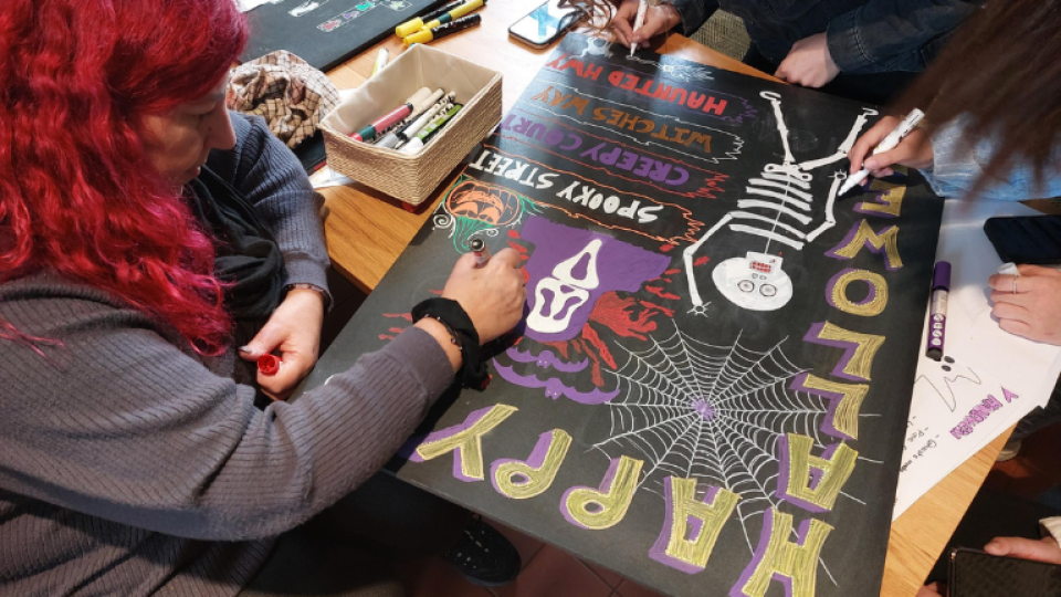 University of West London student volunteers working on a poster for a Halloween event