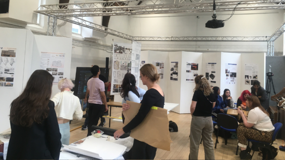 London School of Film, Media and Design students attending the Vestry Hall showcase with work shown around the room on stands.
