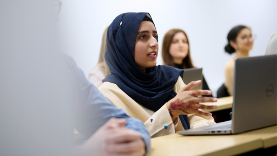 A student in a hijab speaking in a seminar at the University of West London