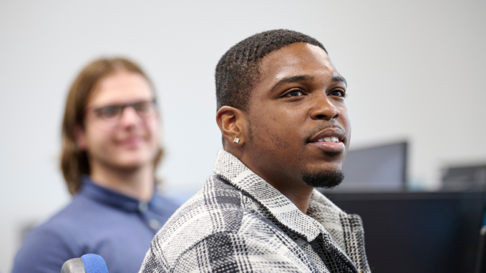 Two students sat in a computer lab looking ahead.