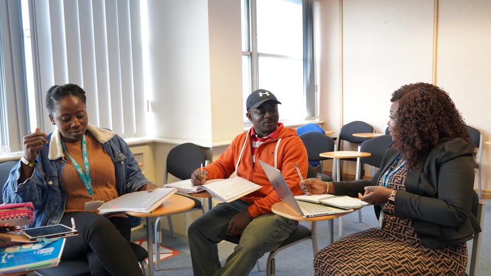 3 students studying together while sitting in a circle