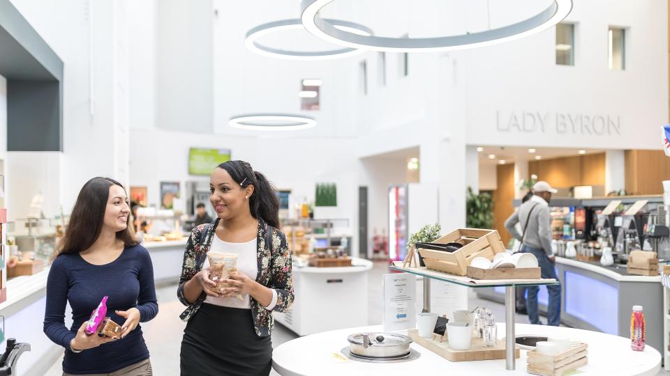 Two students grabbing food and drink in the dining hall