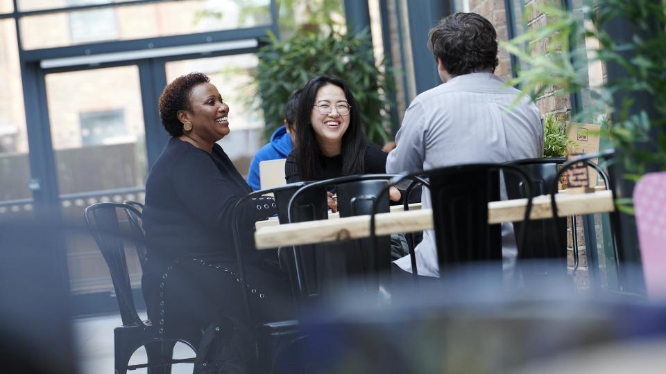 Three students sitting together and laughing