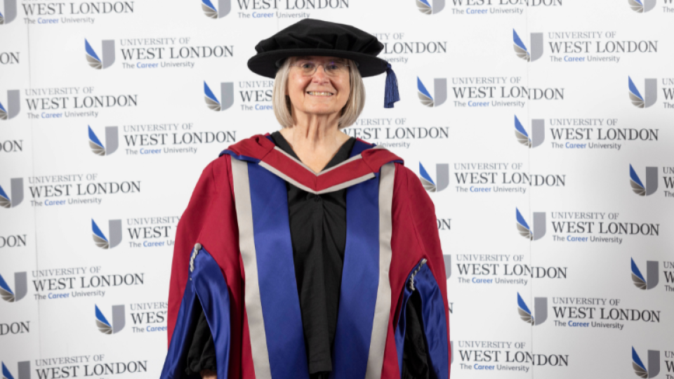 Annette Haworth is wearing a hat and gown as an honoree graduate.