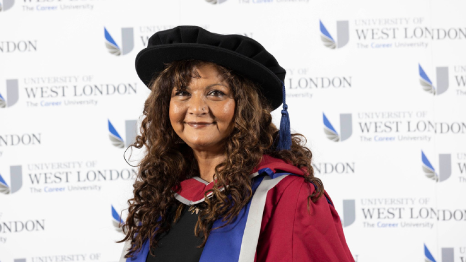  Tanika Gupta MBE is wearing a gown and hat as an honoree graduate