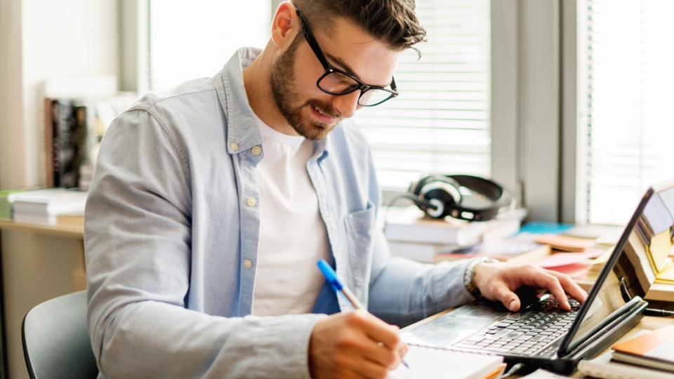 A man working at a laptop in a home study