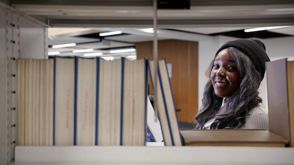 Student in library looking through books