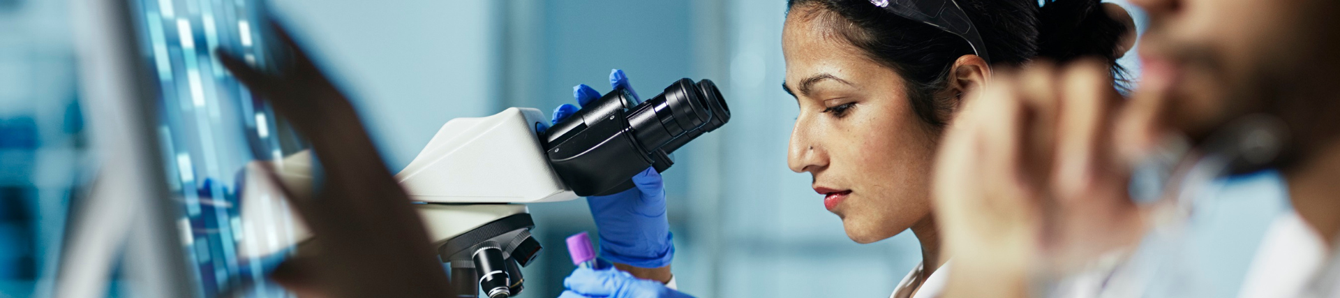 A female forensic scientist using a microscope