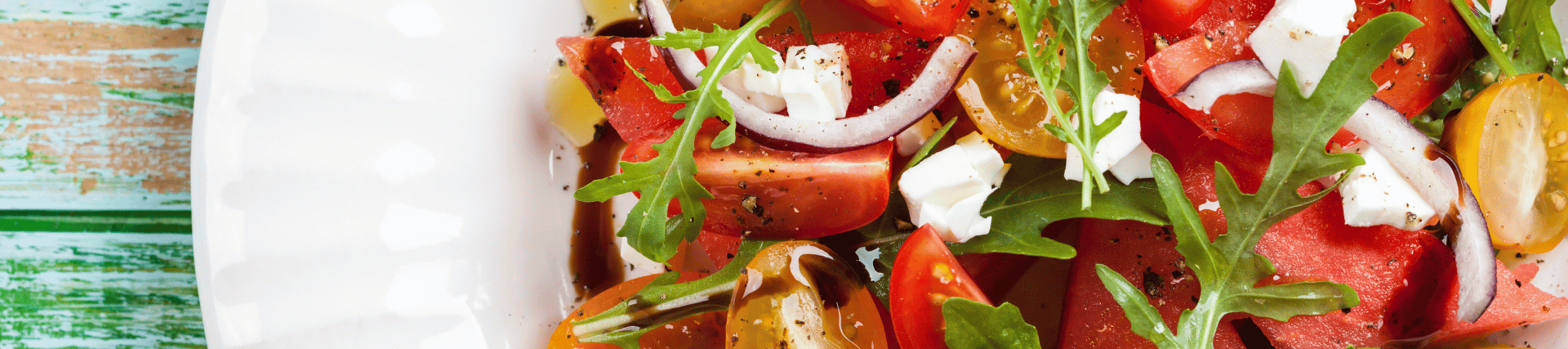 A feta cheese and tomato salad, served on a white plate.