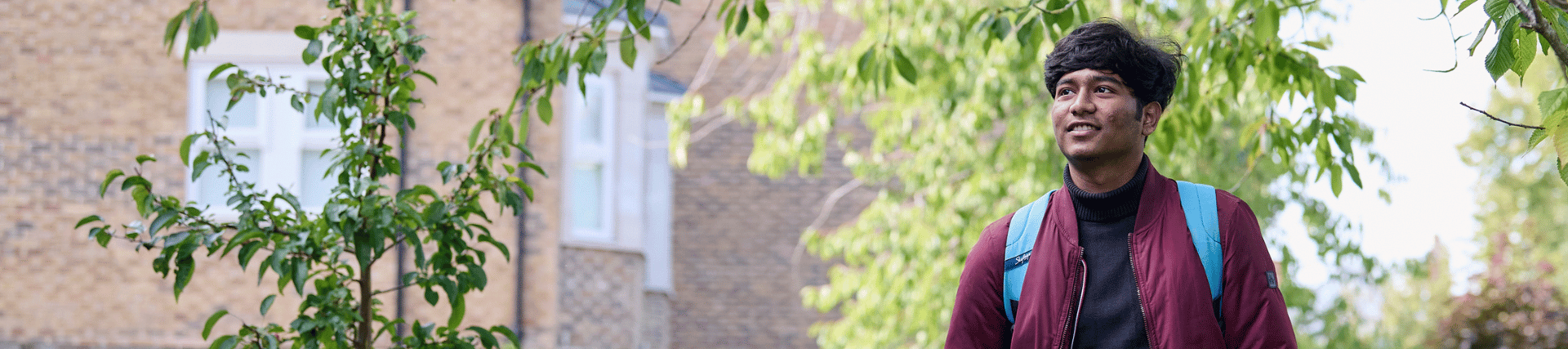 A student walking through the memorial garden, surrounded by nature.