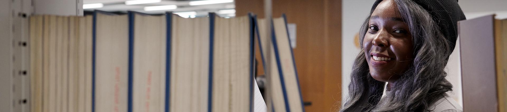 Student in library looking through books