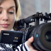 A camera operator, focusing her video camera