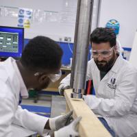 Two male engineers testing timber strength in UWL's concrete lab