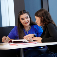 Two students studying together in the Paul Hamlyn Library.