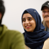 A group of students smiling and studying together in a group session.