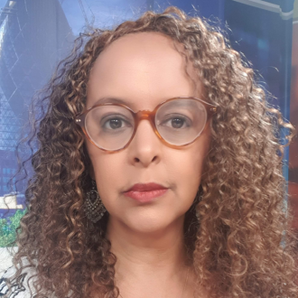 Selam Kidane is wearing glasses and has long curly hair.