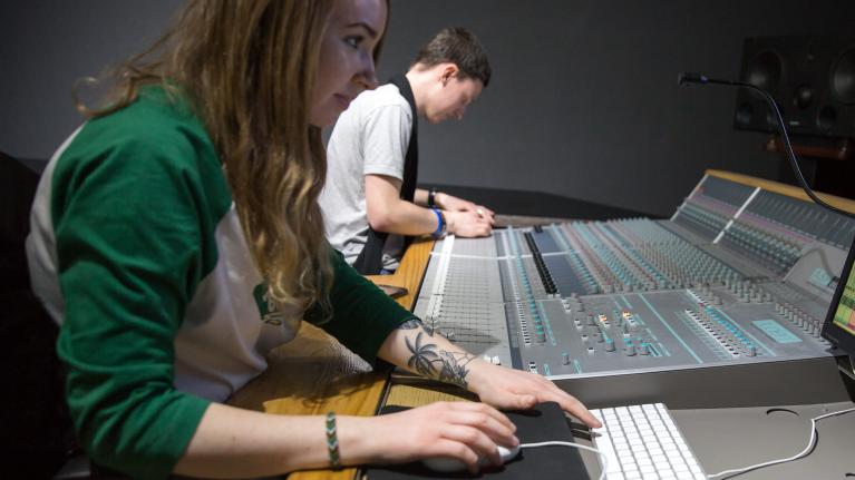 A female and male student at a sound desk